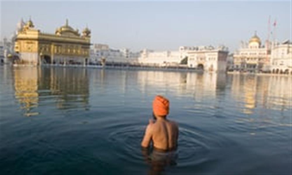 Sikh devotee taking dip at holy sarovar in Golden Temple