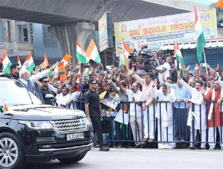 K’taka BJP leaders welcome Modi standing behind barricades; Cong term it slavery K’taka BJP leaders welcome Modi standing behind barricades; Cong term it slavery